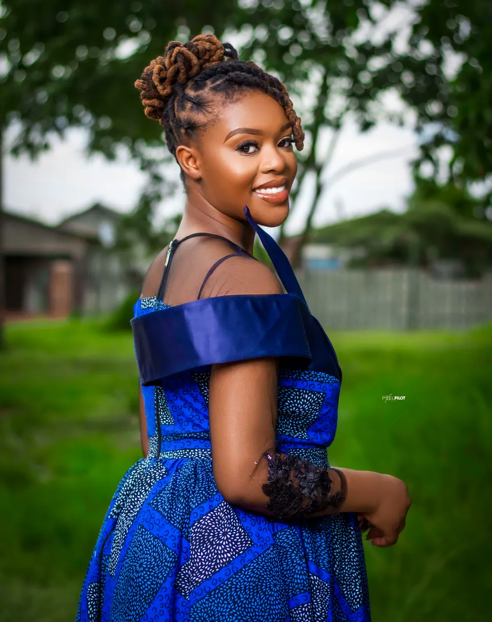 Portrait of a woman in a blue African-print dress with satin shoulder detail